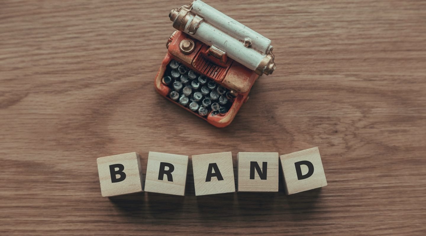top-view-of-typewriter-and-wooden-cube-with-text-brand-on-wooden-background-.jpg